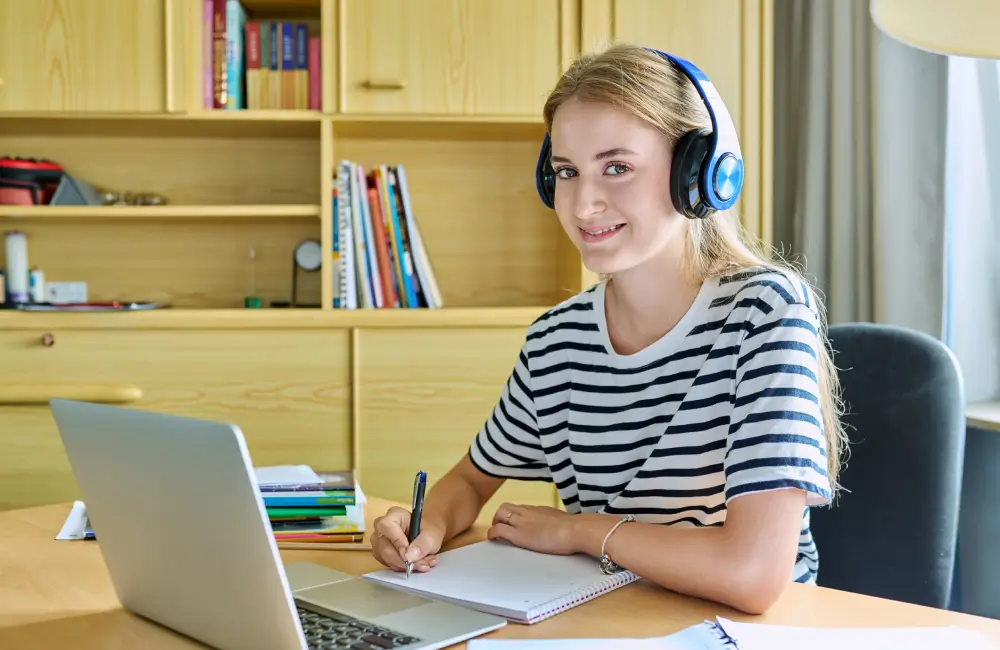 Woman studying with laptop and headphones.